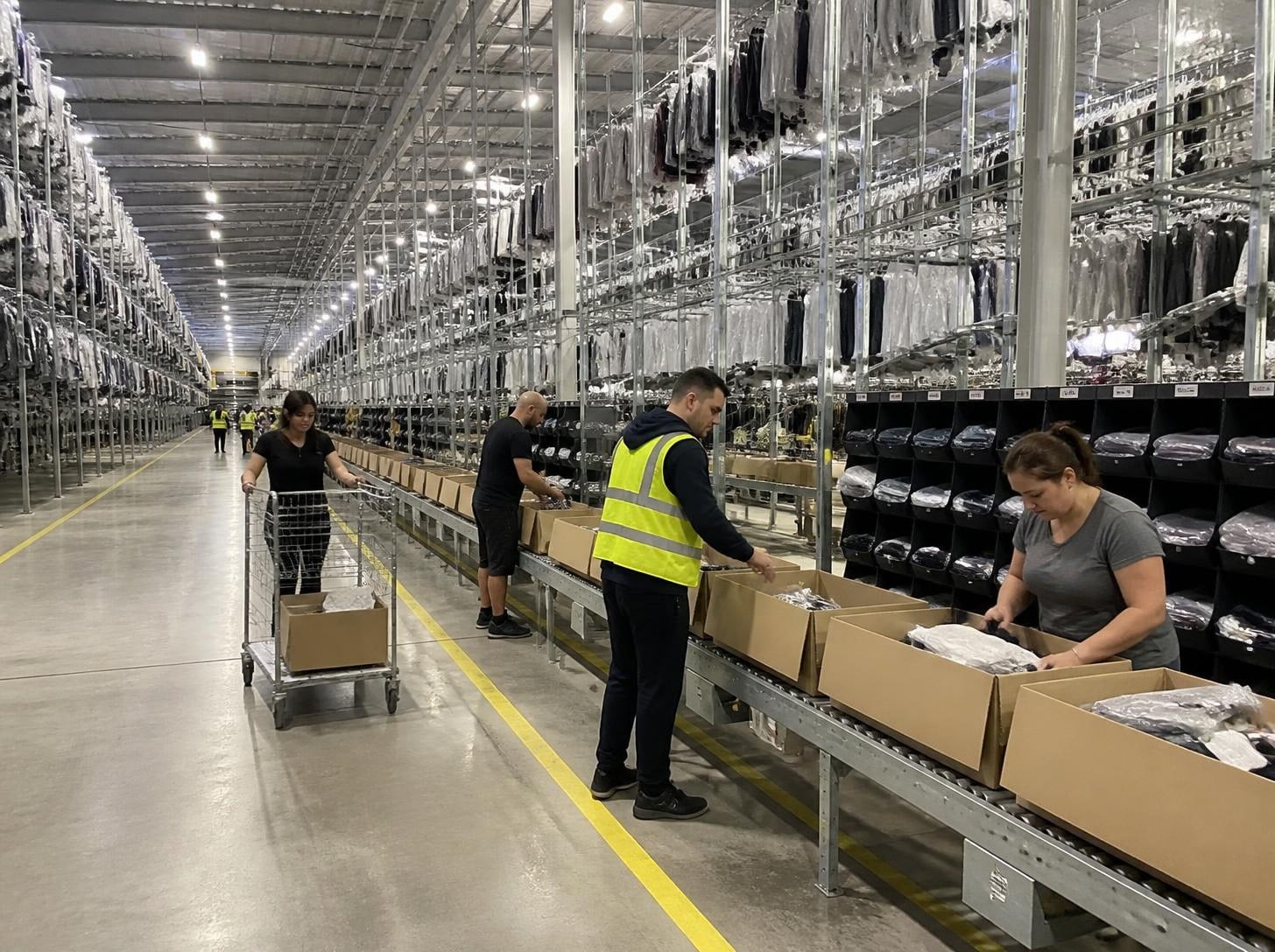 Helle Logistikhalle mit Mitarbeitern in Arbeitskleidung